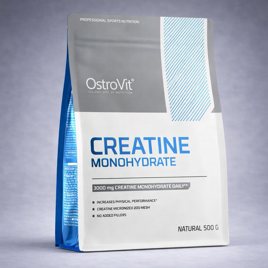 Sachet gris et bleu OstroVit Creatine Monohydrate 500 g posé sur fond neutre dégradé clair, visuel premium pour site e‑commerce musculation, force et performance.